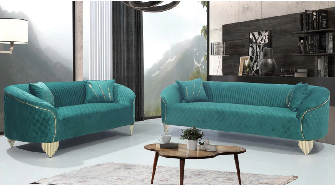 Two green love seat sofas in a living room setting with a coffee table and decor.